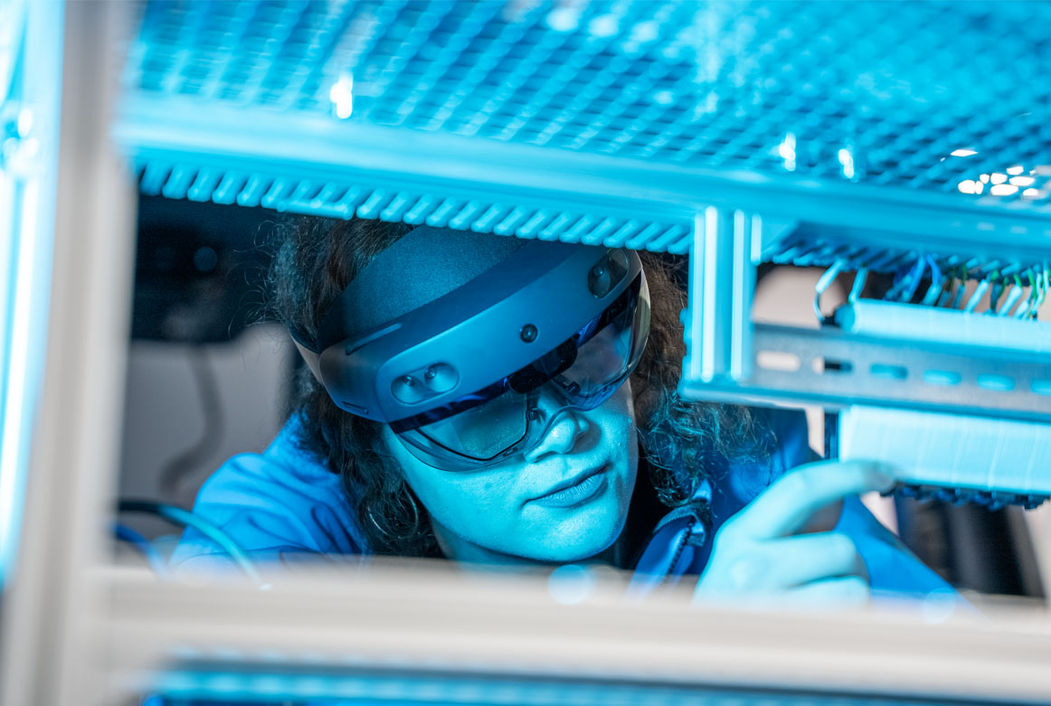 Elektronikerin verkabelt Prototypen mit Unterstützung eines Experten durch die Augemented Reality Brille Hololens 2